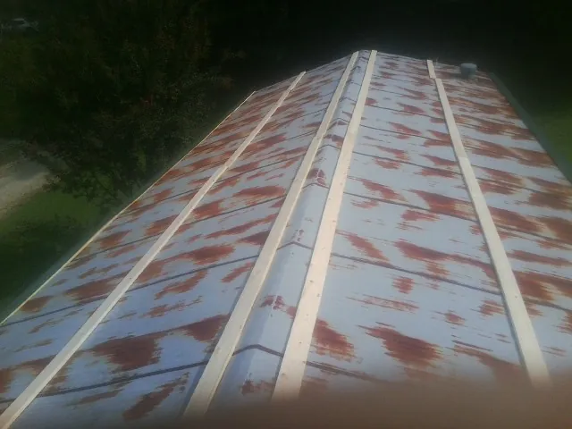 Rusted metal roof panels with new wood purlins before replacement — Storm Damage Roof Repair in Suches by Roofing Brothers