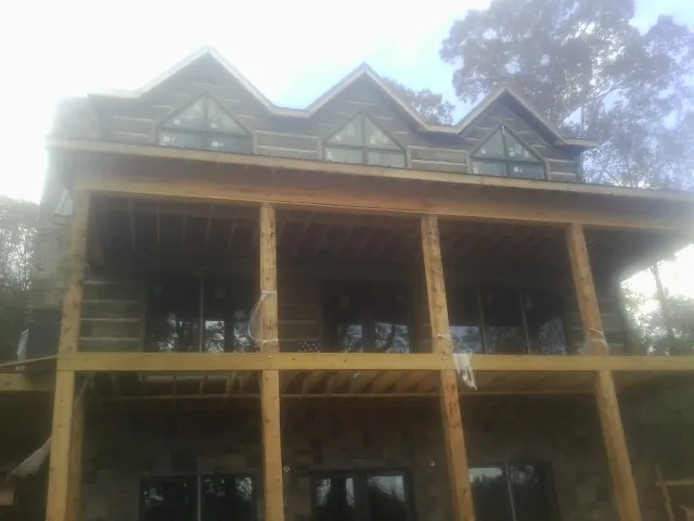 Dormers and porch framing on a large log home under construction — Roof Coating work by our crew in Suches
