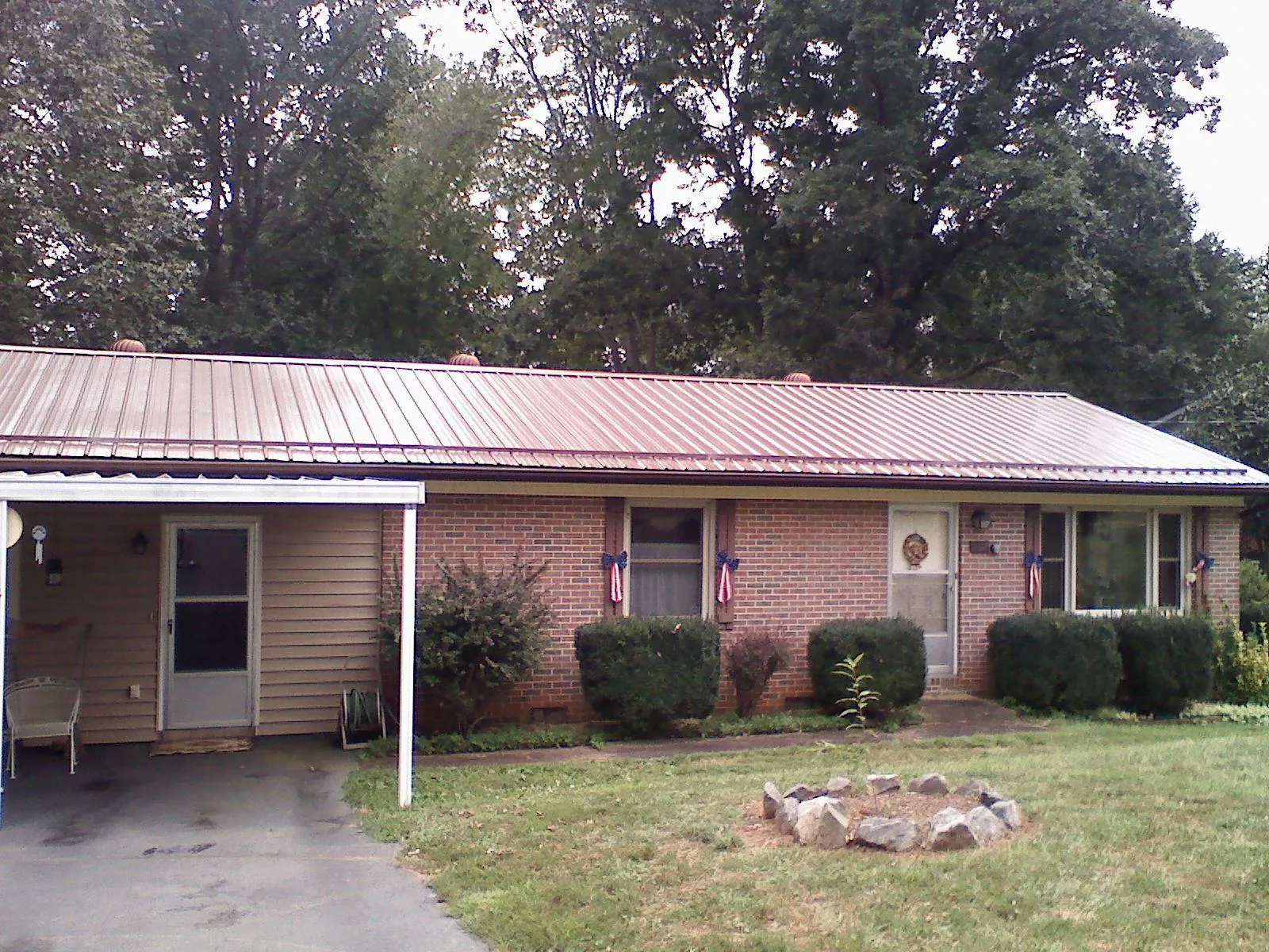 Bronze metal roof and carport on a brick ranch home — Roof Repair work by our crew in Suches